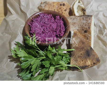 Traditional beetroot appetizer garnished with fresh parsley and served with warm flatbread on parchment paper as a complimentary restaurant starter Traditional beetroot appetizer garnished with fresh parsley and served with warm flatbread on parchment paper as a complimentary restaurant starter 141686580