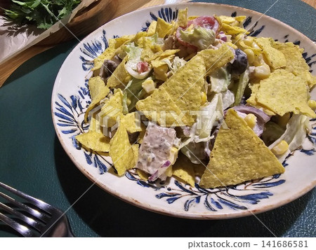Fresh Mexican style chicken salad with tortilla chips, corn, tomatoes and creamy dressing served on decorative ceramic plate Fresh Mexican style chicken salad with tortilla chips, corn, tomatoes and creamy dressing served on decorative ceramic plate 141686581