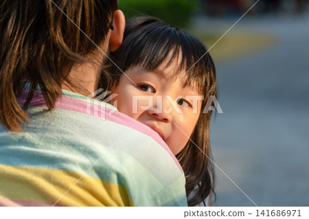 Asian Little Girl Hugging Mother for Comfort and Security Outdoors Asian Little Girl Hugging Mother for Comfort and Security Outdoors 141686971