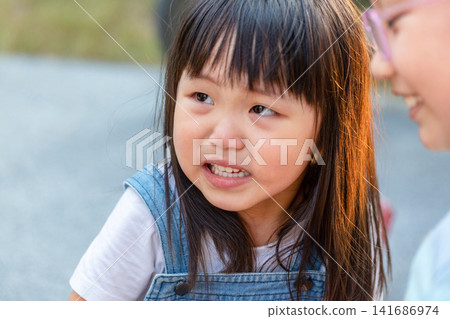 Serious Asian Little Girl Looking at Camera with Sad Expression Serious Asian Little Girl Looking at Camera with Sad Expression 141686974