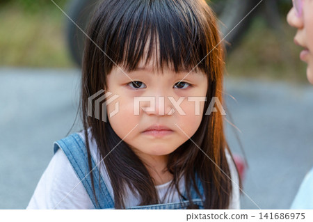 Serious Asian Little Girl Looking at Camera with Sad Expression Serious Asian Little Girl Looking at Camera with Sad Expression 141686975