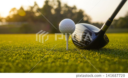 Golf clubs and balls on a green lawn in a beautiful golf course with morning sunshine. Golf clubs and balls on a green lawn in a beautiful golf course with morning sunshine. 141687720