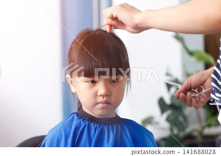 Cute Asian Little Girl Getting Haircut at Home With Different Emotions Cute Asian Little Girl Getting Haircut at Home With Different Emotions 141688028