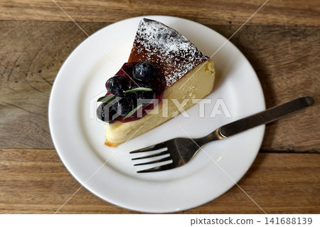 Cheesecake with blueberries and mint leaf on wooden table 141688139