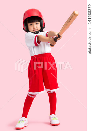 Full length shot of a young girl swinging a wooden baseball bat against a solid pink background. Full length shot of a young girl swinging a wooden baseball bat against a solid pink background. 141688279