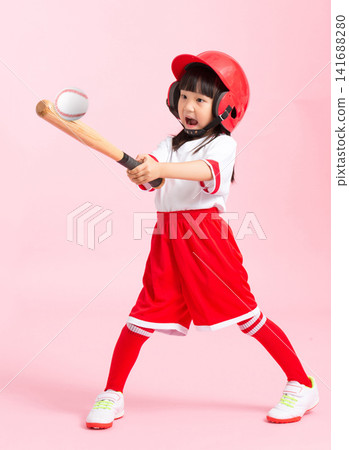 Full length shot of a young girl swinging a wooden baseball bat against a solid pink background. Full length shot of a young girl swinging a wooden baseball bat against a solid pink background. 141688280