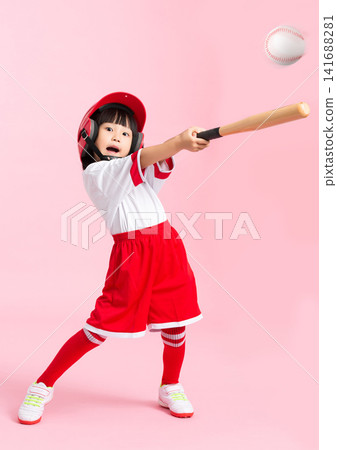 Full length shot of a young girl swinging a wooden baseball bat against a solid pink background. Full length shot of a young girl swinging a wooden baseball bat against a solid pink background. 141688281