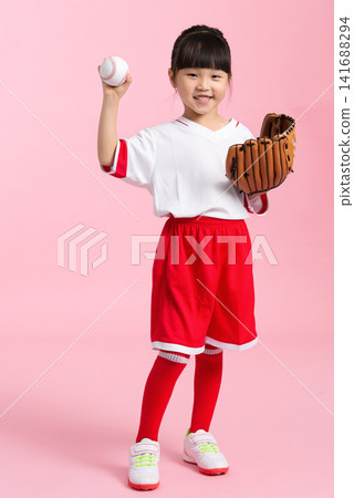 Athletic young girl throwing a baseball while wearing a leather mitt on a pink background. Athletic young girl throwing a baseball while wearing a leather mitt on a pink background. 141688294