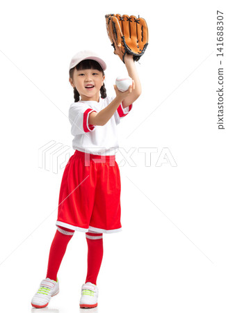 Full length view of a young baseball player raising her gloved hand against a white backdrop. Full length view of a young baseball player raising her gloved hand against a white backdrop. 141688307