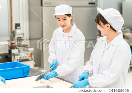 Male and female staff in chef coats preparing chicken (chef, chef, fresh market, food processing) Male and female staff in chef coats preparing chicken (chef, chef, fresh market, food processing) 141688696