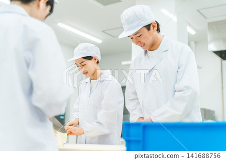 男女廚房工作人員在廚房切捲心菜 男女廚房工作人員在廚房切捲心菜 141688756