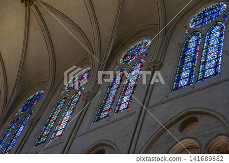 Interior and stained glass windows of Notre Dame Cathedral in Paris, France Interior and stained glass windows of Notre Dame Cathedral in Paris, France 141689882