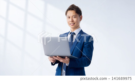 帶筆記型電腦的微笑的男性商人 帶筆記型電腦的微笑的男性商人 141689975