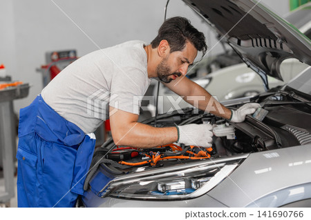 Professional EV Car Service, Male workers Electricity Vehicle Fix Maintenance in EV Garage workshop. Professional EV Car Service, Male workers Electricity Vehicle Fix Maintenance in EV Garage workshop. 141690766