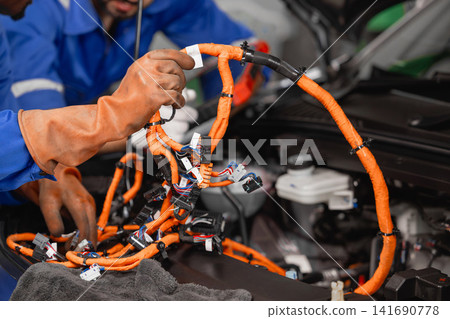 Professional EV Car Service, Male worker Electricity Vehicle Fix Maintenance in EV Garage workshop. Professional EV Car Service, Male worker Electricity Vehicle Fix Maintenance in EV Garage workshop. 141690778