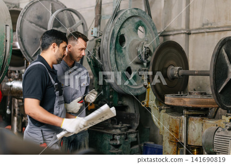 Engineer male workers team working together service maintenance machine in workshop, Heavy industry. Engineer male workers team working together service maintenance machine in workshop, Heavy industry. 141690819