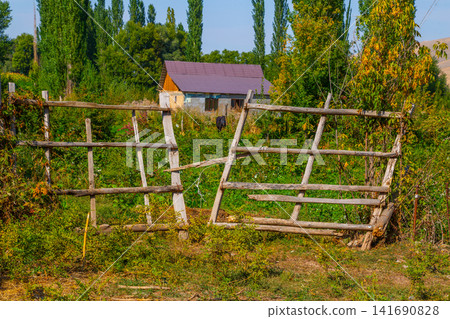 Rustic Wooden Fence and Rural House in Kyrgyzstan Rustic Wooden Fence and Rural House in Kyrgyzstan 141690828