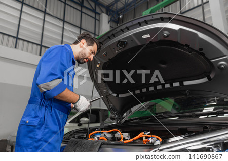 Professional EV Car Service, Male workers Electricity Vehicle Fix Maintenance in EV Garage workshop. Professional EV Car Service, Male workers Electricity Vehicle Fix Maintenance in EV Garage workshop. 141690867