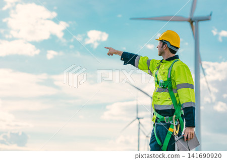 engineer male working outdoor with safety at wind turbines clean energy power station background. engineer male working outdoor with safety at wind turbines clean energy power station background. 141690920