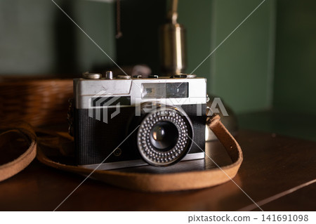 Vintage Camera on Wooden Table. Vintage Classic retro style film camera on Wooden Table indoor Vintage Camera on Wooden Table. Vintage Classic retro style film camera on Wooden Table indoor 141691098