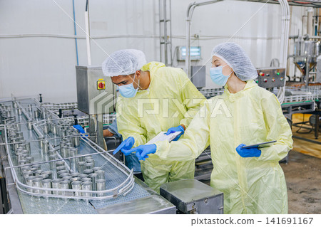 Food industry people worker, Quality control staff inspecting cannery food product in production line conveyor belt in food factory plant. Food industry people worker, Quality control staff inspecting cannery food product in production line conveyor belt in food factory plant. 141691167
