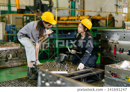 Women workers engineer team hard working in heavy industry factory Engineer training with supervisor 141691247