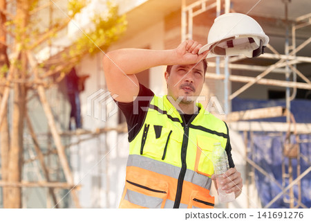 Outdoors worker impact from Heatwave in Europe, Engineer male construction builder sweating Outdoors worker impact from Heatwave in Europe, Engineer male construction builder sweating 141691276