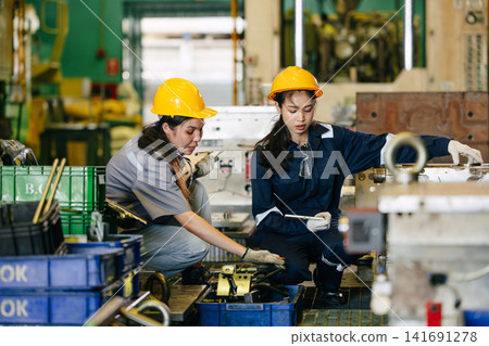 Women workers engineer team hard working in heavy industry factory Engineer training with supervisor Women workers engineer team hard working in heavy industry factory Engineer training with supervisor 141691278
