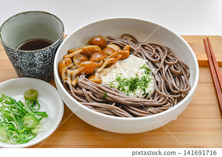 冷蕎麥麵配磨碎的山藥、調味料和滑子菇。 冷蕎麥麵配磨碎的山藥、調味料和滑子菇。 141691716