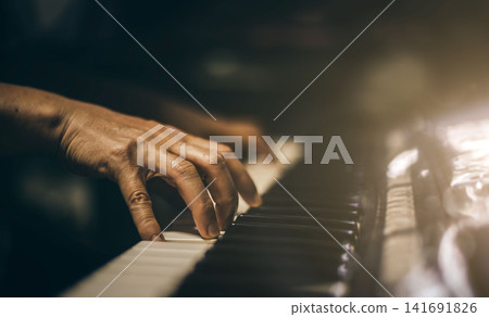 Close-up of a music performers hand playing the piano. Close-up of a music performers hand playing the piano. 141691826