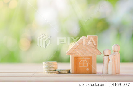 House and coins placed on the table with happy wooden doll family placed on nature bokeh. planning savings money of coins to buy a home. House and coins placed on the table with happy wooden doll family placed on nature bokeh. planning savings money of coins to buy a home. 141691827