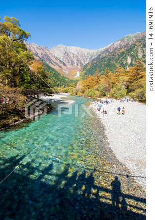 上高地的秋天:從河童橋上眺望雄偉的穗高山脈和清澈的梓川河水(長野縣松本市) 上高地的秋天:從河童橋上眺望雄偉的穗高山脈和清澈的梓川河水(長野縣松本市) 141691916