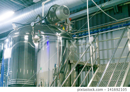 Stainless steel tanks for mixing and fermentation reactor in a modern factory Stainless steel tanks for mixing and fermentation reactor in a modern factory 141692105