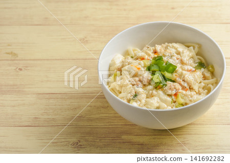 Udon noodles with a thick sauce made from ground chicken and tofu. Udon noodles with a thick sauce made from ground chicken and tofu. 141692282