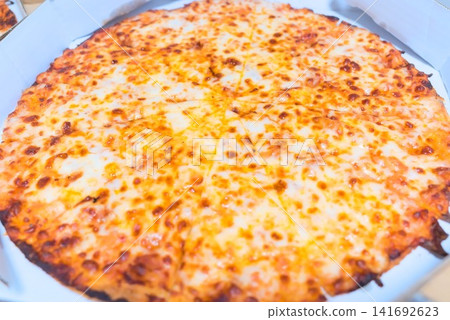 A food photograph of a freshly baked whole cheese pizza in its box. A food photograph of a freshly baked whole cheese pizza in its box. 141692623
