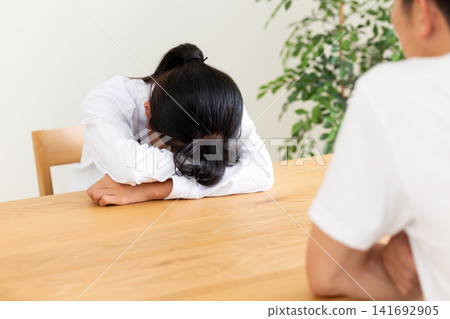 A middle school student in her uniform breaks down in tears on the living room table. A middle school student in her uniform breaks down in tears on the living room table. 141692905