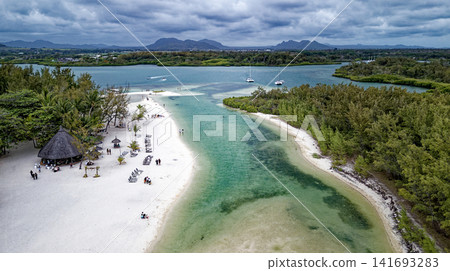 Aerial high angle shot of the sandbar beach, turquoise lagoon channel, and anchored boats at Ile aux Cerfs, Mauritius Aerial high angle shot of the sandbar beach, turquoise lagoon channel, and anchored boats at Ile aux Cerfs, Mauritius 141693283