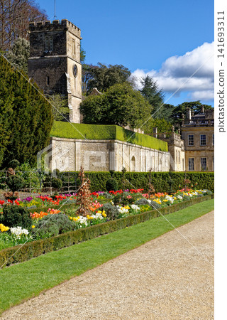 Vibrant spring flower borders and manicured grass paths leading to the historic mansion at Dyrham Park, England Vibrant spring flower borders and manicured grass paths leading to the historic mansion at Dyrham Park, England 141693311