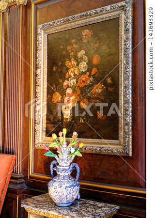 Antique floral oil painting and a Delftware tulipiere vase on a marble console table at Dyrham Park, England Antique floral oil painting and a Delftware tulipiere vase on a marble console table at Dyrham Park, England 141693329