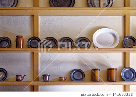 Antique pewter plates and ceramic earthenware jars on wooden dresser shelves at Dyrham Park Antique pewter plates and ceramic earthenware jars on wooden dresser shelves at Dyrham Park 141693338