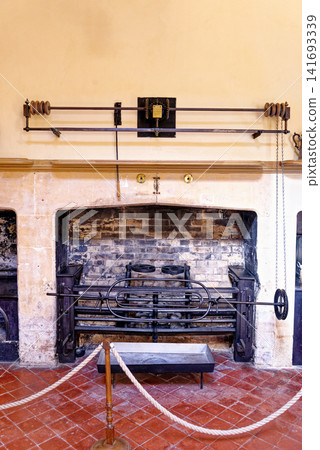Antique roasting spit mechanism and large open brick fireplace inside the historic kitchen at Dyrham Park Antique roasting spit mechanism and large open brick fireplace inside the historic kitchen at Dyrham Park 141693339