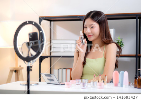 Young asian woman facial spray or serum on social media, content creator. Young asian woman facial spray or serum on social media, content creator. 141693427