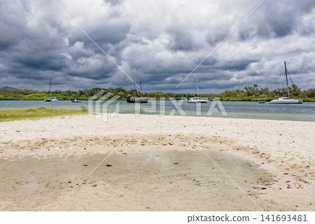 Traditional pirate style boat and a modern catamaran anchored in a tropical lagoon channel at Ile aux Cerfs, Mauritius Traditional pirate style boat and a modern catamaran anchored in a tropical lagoon channel at Ile aux Cerfs, Mauritius 141693481