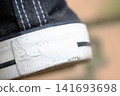 A white label on the back of the black sneakers. 141693698