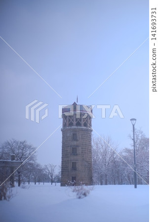 一座瞭望塔矗立在白雪皚皚的公園裡,構成了一幅寧靜的冬日景象。 一座瞭望塔矗立在白雪皚皚的公園裡,構成了一幅寧靜的冬日景象。 141693731