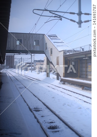 冬季,當地火車站的月台和鐵軌被白雪覆蓋。 冬季,當地火車站的月台和鐵軌被白雪覆蓋。 141693787