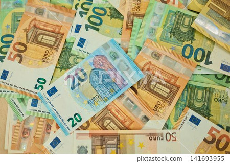 Mixed 20, 50 and 100 euro banknotes are scattered in a layered cash background. European currency concept for spending, savings, budgeting and everyday finance Mixed 20, 50 and 100 euro banknotes are scattered in a layered cash background. European currency concept for spending, savings, budgeting and everyday finance 141693955