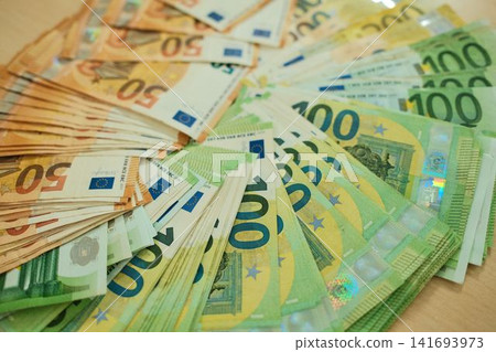 Euro banknotes are arranged in grouped stacks by denomination on a wooden surface. Cash savings and wealth concept for finance, budgeting, investment and banking use Euro banknotes are arranged in grouped stacks by denomination on a wooden surface. Cash savings and wealth concept for finance, budgeting, investment and banking use 141693973