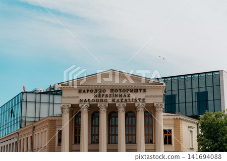 Facade of the National Theatre in Subotica, Serbia under a bright sky. Historic architecture and cultural heritage in the city center Facade of the National Theatre in Subotica, Serbia under a bright sky. Historic architecture and cultural heritage in the city center 141694088