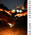 person playing with handheld fireworks 141694150